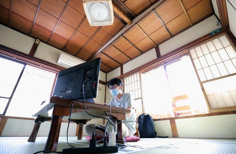 老舗旅館の「鳳明館」にパソコンのディスプレーを持ち込み、和室で仕事をする大学講師の森田光治良さん=東京都文京区で2020年5月12日、宮武祐希撮影