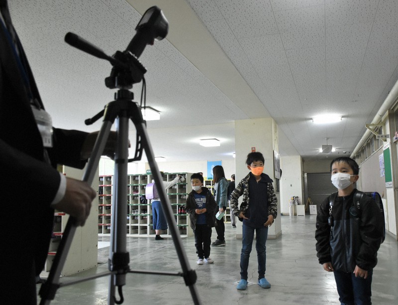 寄贈されたサーマルカメラで検温する児童たち=宮城県塩釜市立杉の入小で2020年5月19日午前8時21分、藤田花撮影