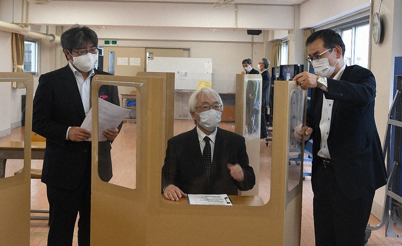 ダンボール製の仕切りについて関係者から説明を受ける伊藤浩樹校長(中央)=福島県南相馬市立原町第一中学校で2020年5月19日、高橋秀郎撮影