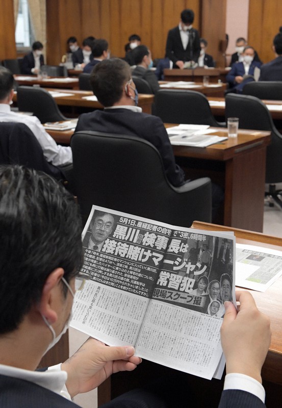 衆院内閣委員会で黒川氏に関する雑誌記事のコピーを読む議員=国会内で2020年5月20日午後2時41分、竹内幹撮影