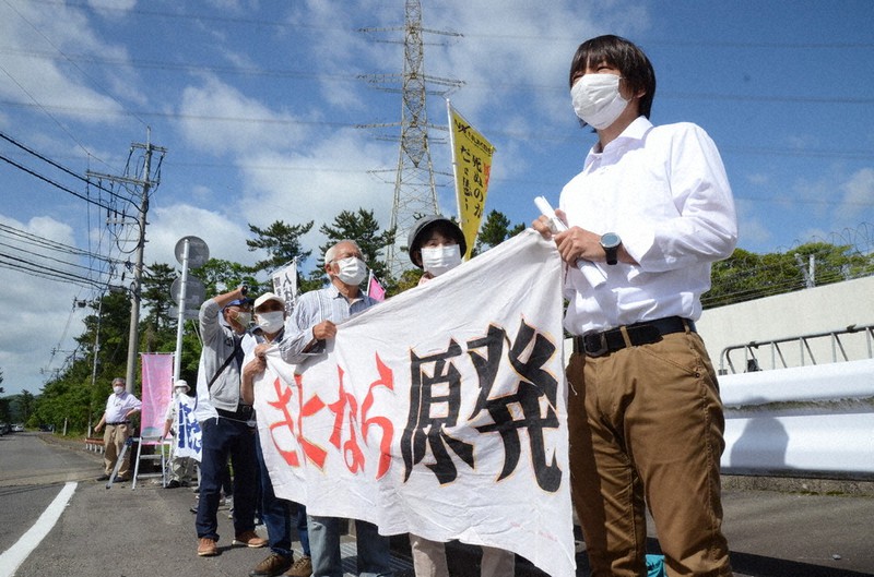 川内原発ゲート前で、横断幕を掲げて稼働反対を訴える人たち