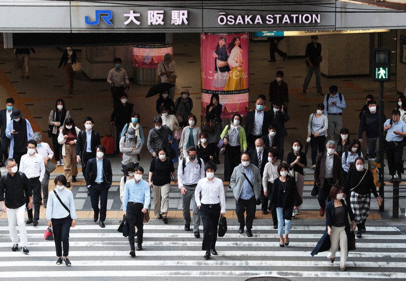 緊急事態宣言解除から一夜明け、通勤で横断歩道を渡る人たち=大阪市北区で22日午前、小出洋平撮影