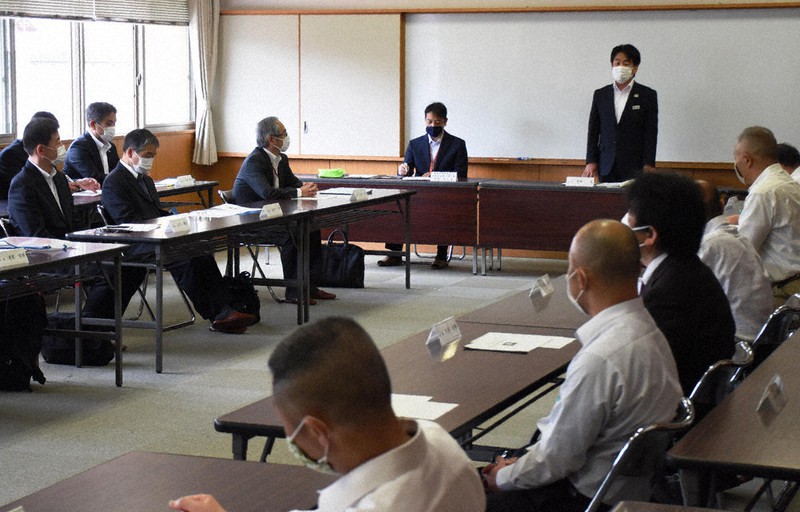 愛媛県高野連の会議冒頭、起立してあいさつする忽那浩会長=松山市旭町の県立松山商高で、中川祐一撮影