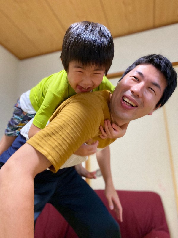 ひろみちお兄さん直伝の「親子体操」の一つ「ロッククライミング」を楽しむ5歳の長男(上)は笑顔があふれていた=自宅で2020年5月18日、家族撮影