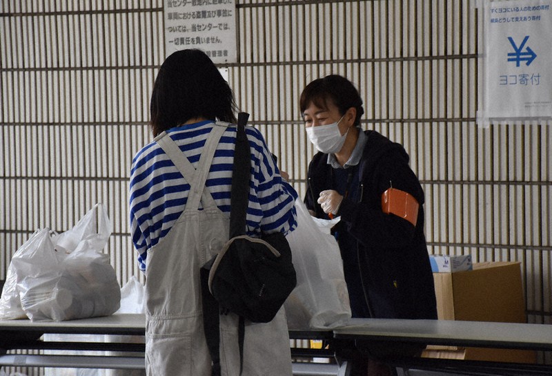 食料を受け取る学生(左)=横浜市中区で