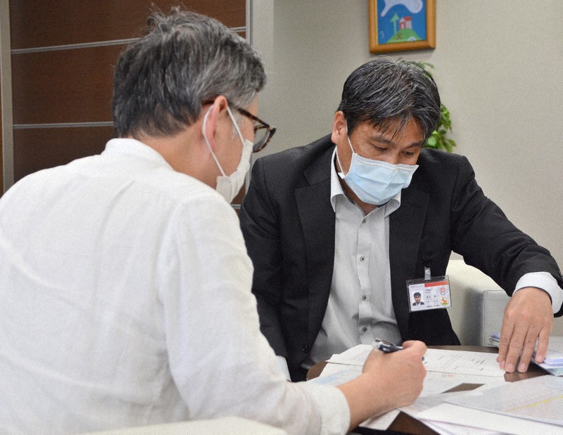 実質無利子融資を申し込む個人事業主の男性(左)。日銀はこうした融資を後押しする=福岡市中央区で2020年5月7日、久野洋撮影
