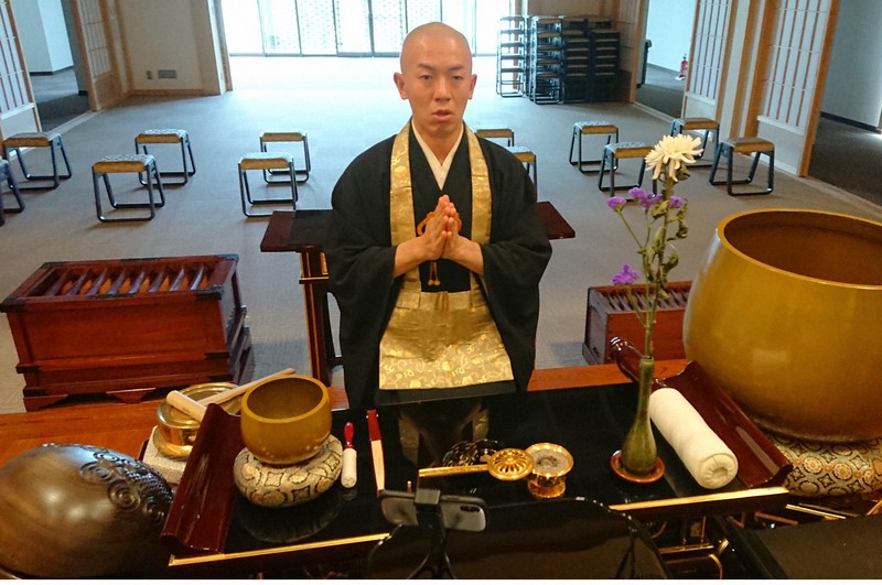 本堂での「読経ライブ」の実演風景を見せてくれた池田智光住職。手前に撮影用のスマートフォンを置いている=東京都練馬区で2020年5月15日、鈴木琢磨撮影