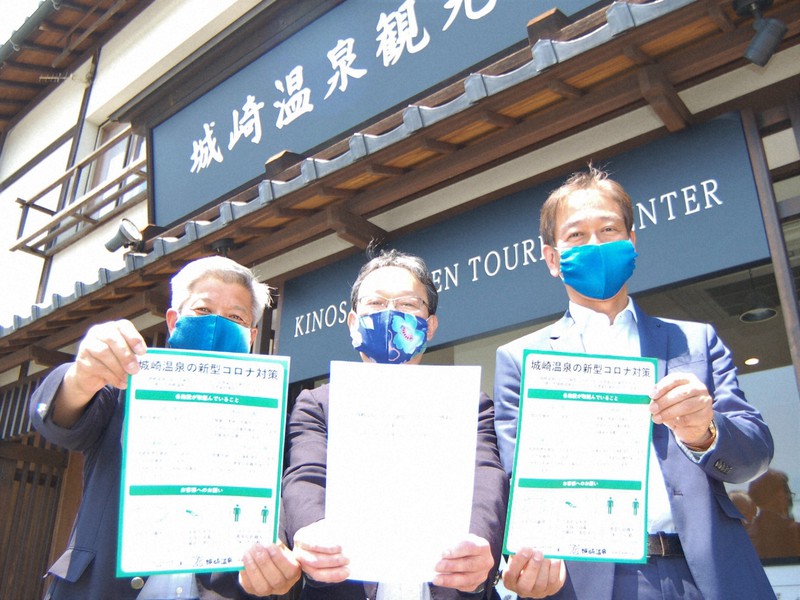 「城崎温泉における新型コロナウイルス感染症対策ガイドライン」のチラシを持つ高宮浩之・城崎温泉観光協会長(右)と芹澤正志・城崎温泉旅館協同組合理事長(中央)=豊岡市城崎町湯島で2020年5月29日午前11時3分、村瀬達男撮影