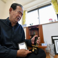 佐藤好重さんの遺影と、ネックレスをかけた位牌（いはい）を手にしながら話す山崎正則さん。ネックレスには事件当時の血痕が残っていた＝神奈川県横須賀市で2020年3月3日、宮間俊樹撮影