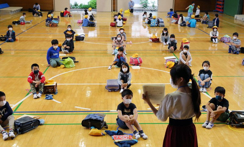 分散登校し、体育館に集まり間隔を空けて座る葛飾小学校3年生の児童ら=東京都葛飾区で2020年6月1日午前8時47分、長谷川直亮撮影