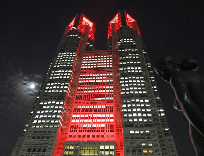 新型コロナウイルスの感染者が再び増加傾向となり、「東京アラート」が初めて発令され赤色にライトアップされた東京都庁=東京都新宿区で2020年6月2日午後11時、手塚耕一郎撮影