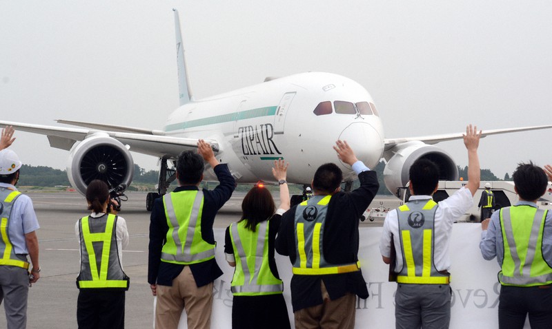 出発する初便に手を振って見送る「ZIPAIR Tokyo」と日本航空の社員ら=成田空港で2020年6月3日午後5時17分、中村宰和撮影