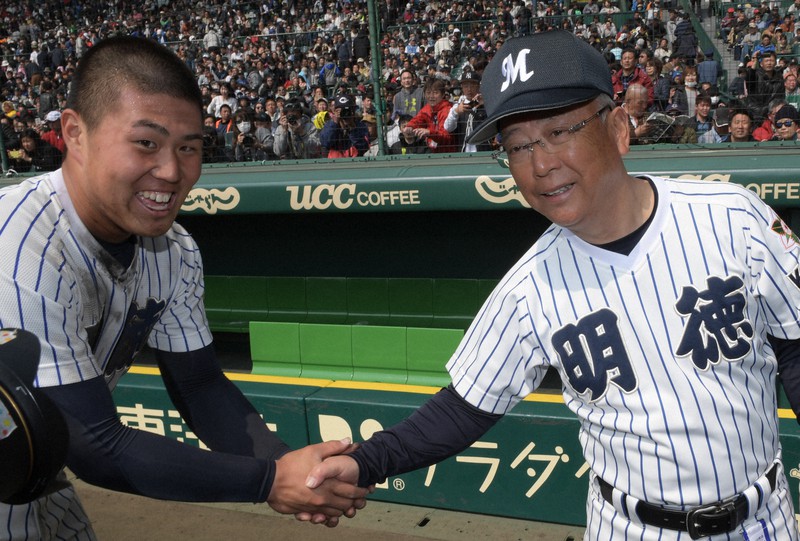 第90回記念選抜大会2回戦の中央学院戦で史上5人目の甲子園春夏通算50勝を挙げた明徳義塾の馬淵監督（右）。試合後、サヨナラ本塁打を打った谷合と握手をする＝阪神甲子園球場で2018年3月25日、平川義之撮影