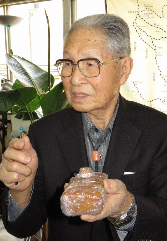 「一日に配給されたパンの大きさはこれぐらい」。わかりやすいように、パンを持参して説明した政岡さん=大阪市で