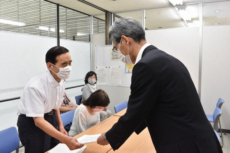 視覚障害者への支援に関する要望書を山下昭一・浜松市健康福祉部長(右)に手渡す安松和男・浜松市視覚障害者福祉協会会長=静岡県浜松市中区元城町で