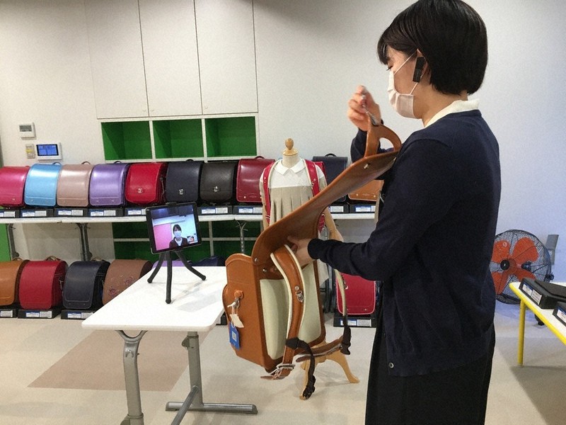 タブレット端末に映る客に向けてランドセルを販売する百貨店従業員=東京都新宿区で2020年5月29日(三越伊勢丹ホールディングス提供)