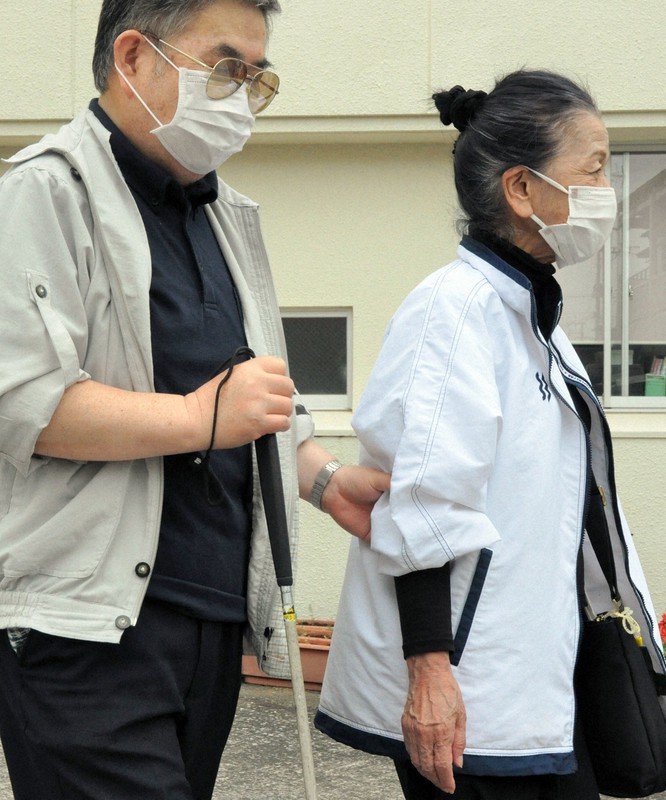 視覚障害者を先導するガイドヘルパー(右)。「間隔1メートル以上」は不可能だ=宮崎市祇園の宮崎市心身障害者福祉会館前で2020年5月15日、杣谷健太撮影