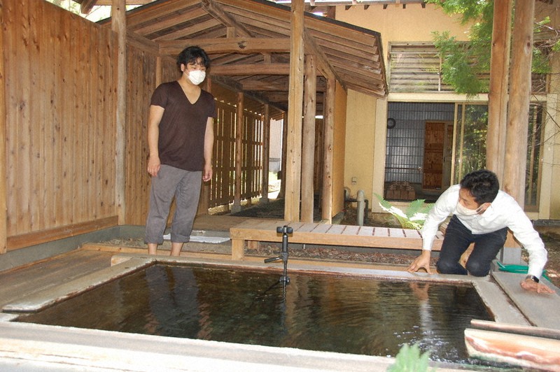 草津温泉のVR映像を撮影する佐藤健太さん(左)と金井一篤さん=群馬県草津町で