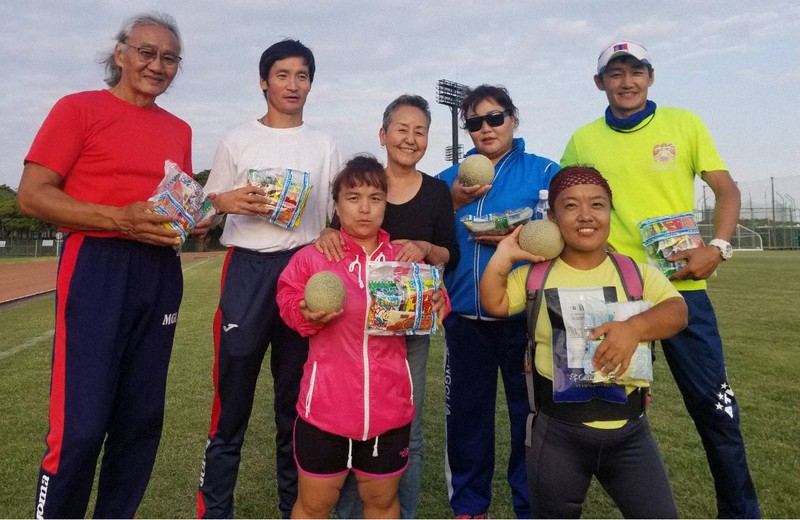 市民の女性(後列中央)からメロンや菓子の差し入れを受けたパラ陸上のモンゴル代表チームの選手たち=静岡県焼津市で2020年6月4日、焼津市提供