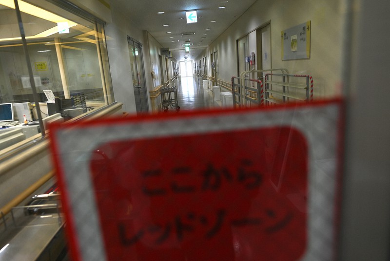 感染の危険度に応じて赤、黄、緑の3色に区分された病院のフロア。「レッドゾーン」と書かれた張り紙の奥には病室がある=大阪市淀川区の市立十三市民病院で2020年6月2日、久保玲撮影