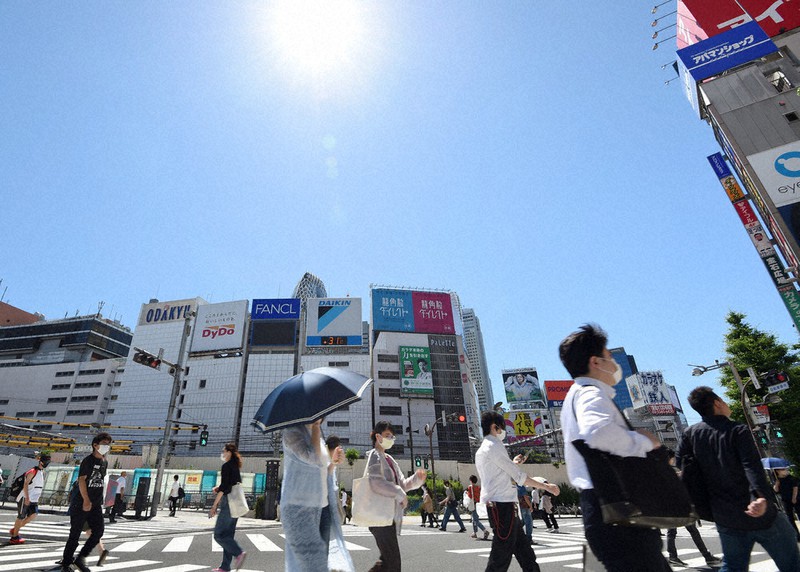 強い日差しの中、横断歩道を歩く人々=東京都新宿区で、西夏生撮影
