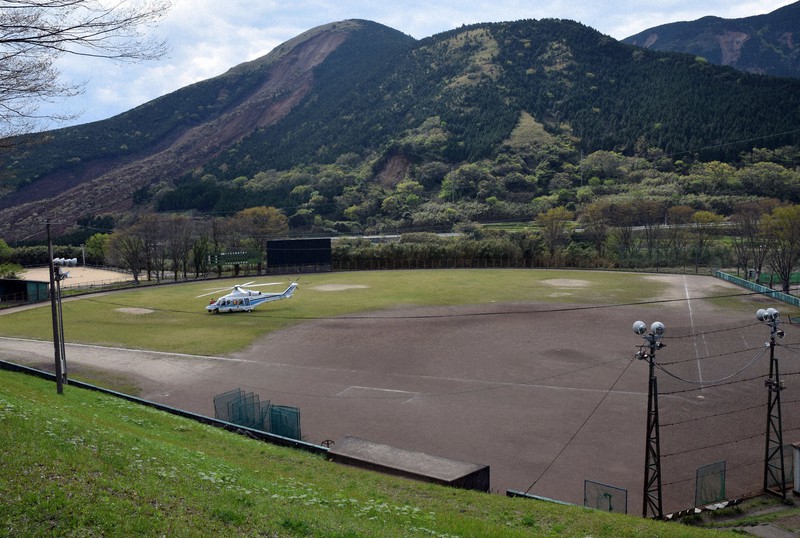地震発生直後の東海大九州野球部グラウンド。地割れができ、外野は救助活動に使うヘリの駐機場所になった。左後方は阿蘇大橋を押し流した土砂崩れ=熊本県南阿蘇村の東海大阿蘇キャンパスで2016年4月16日午後3時1分、浅野翔太郎撮影