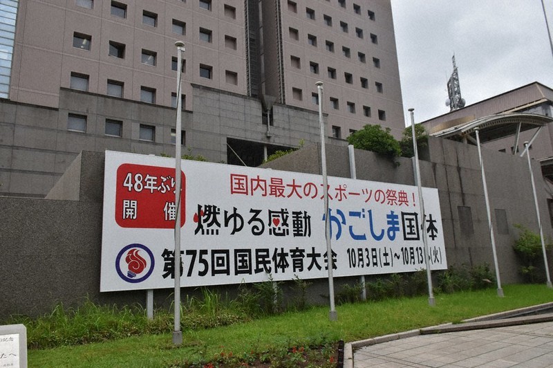 鹿児島県庁(奥)の敷地に立てられた国体のPR用看板。「48年ぶり開催」「燃ゆる感動」などとアピールしている