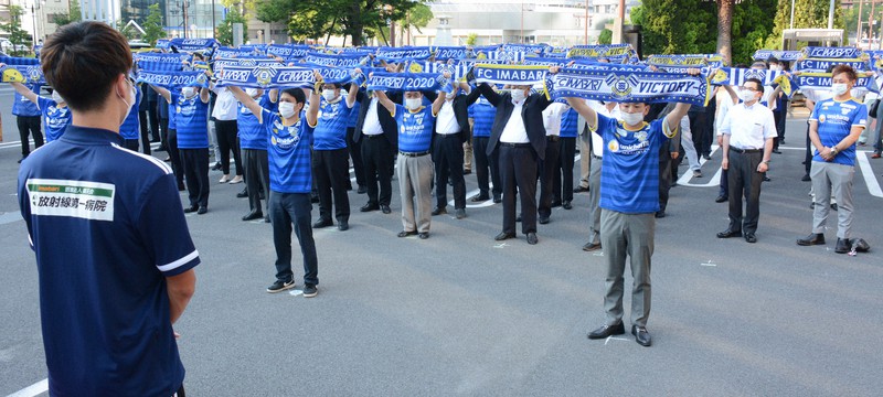 FC今治・楠美圭史主将(左手前)らに「エアエール」を送る今治市職員ら=愛媛県今治市別宮町1で2020年6月24日夕、松倉展人撮影
