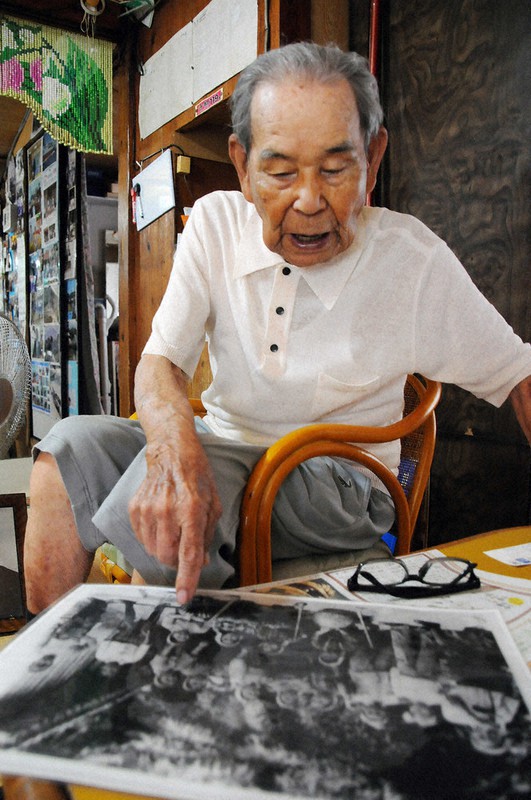 沖縄戦で亡くなった姉の生前の写真を見つめ、悔いを口にする中村武次郎さん=沖縄県座間味村の慶留間島で11日、遠藤孝康撮影