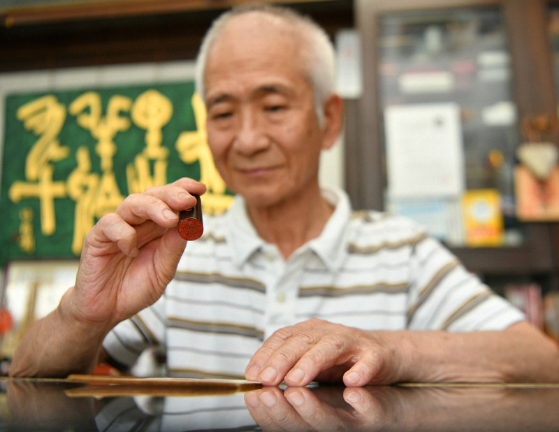 判子を見つめる「博栄堂印房」3代目社長の上田さん=熊本市中央区で2020年6月10日午後3時30分、清水晃平撮影