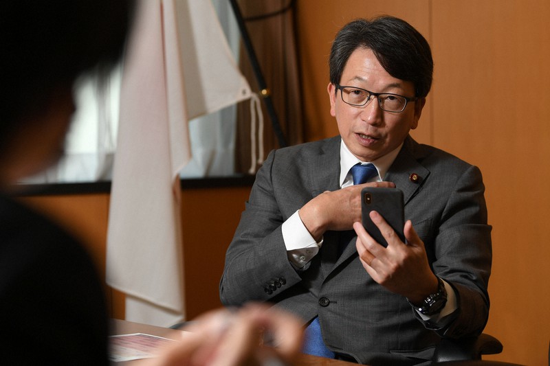 「接触アプリ」の導入についてスマートフォンを片手に記者のインタビューに答える平将明副内閣相=東京都千代田区で、北山夏帆撮影