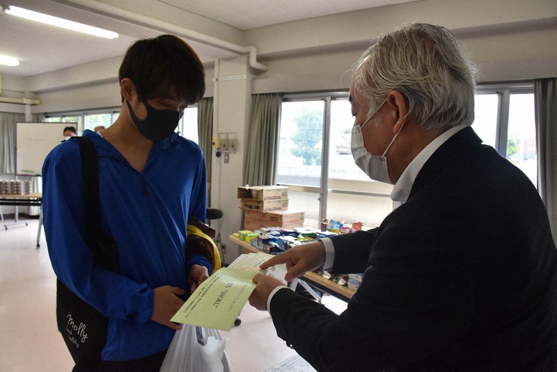 商品券を受け取る学生=横浜市神奈川区で、宮島麻実撮影