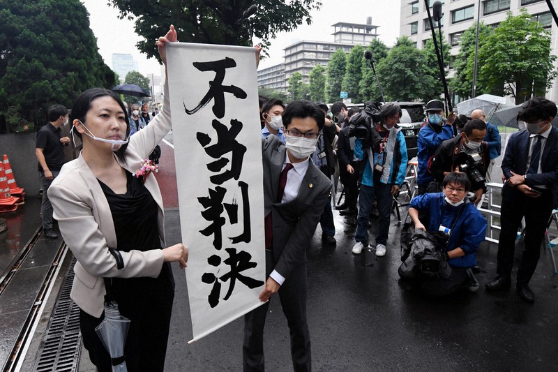 東京地裁の判決後、「不当判決」と書かれた垂れ幕を掲げる原告の弁護士ら=東京都千代田区で2020年6月30日午後2時12分、宮間俊樹撮影