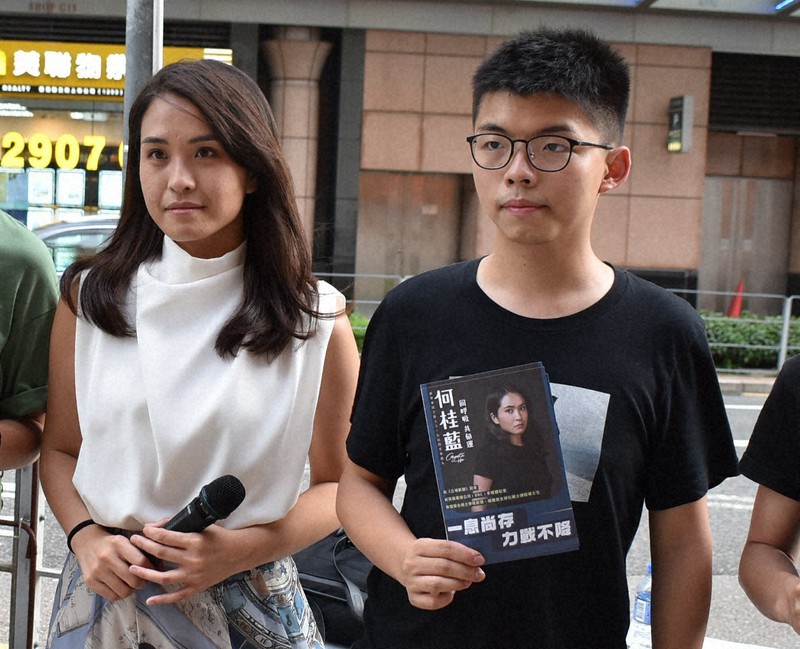 立法会選への出馬を目指す女性(左)の応援演説に駆けつけた黄之鋒氏(右)=香港・宝琳駅前で2020年6月26日、福岡静哉撮影