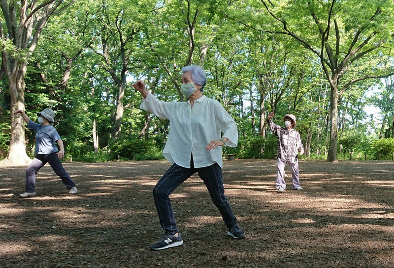 石神井公園の広場で太極拳をする大崎博子さん(中央)=東京都練馬区で、鈴木琢磨撮影