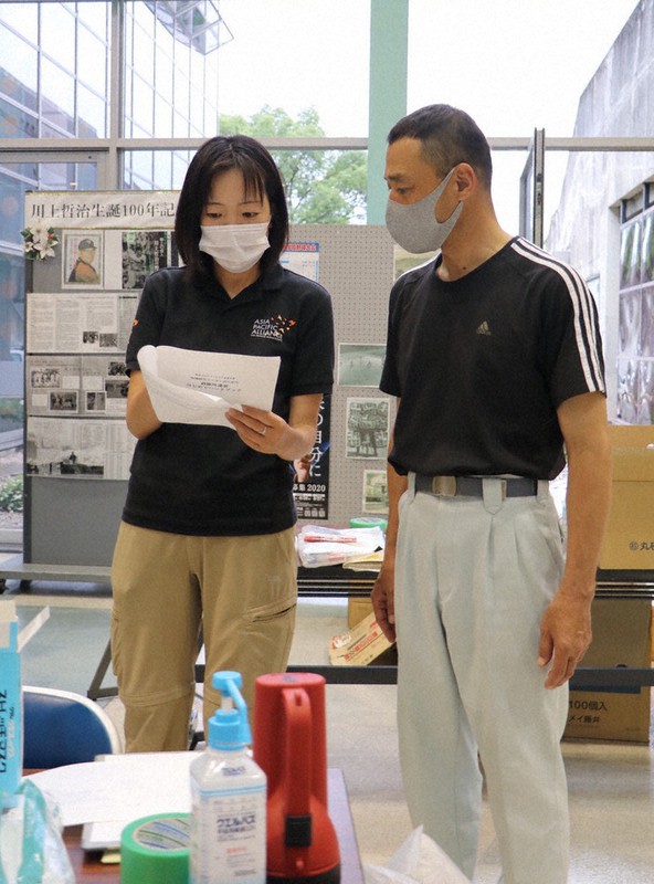 熊本県人吉市の避難所運営者と話す根木事務局長(左)=A-PADジャパン提供