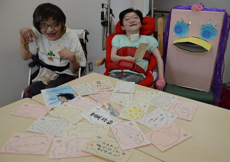 地域住民からのメッセージが書かれたはがきを手にする武藤ゆかりさん(右)と清水三季さん。武藤さんの隣にあるのはアマビエをイメージした、返信はがきを入れるポスト=兵庫県西宮市で、井上元宏撮影