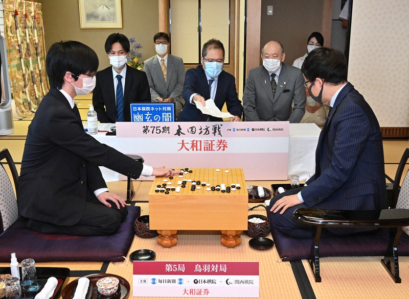 第75期本因坊決定戦七番勝負第5局の2日目の対局が始まり、封じ手を打つ芝野虎丸名人(左)。右は本因坊文裕=三重県鳥羽市の戸田家で2020年7月9日午前9時4分、兵藤公治撮影