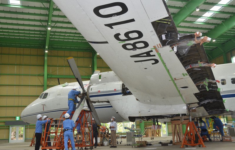 YS-11量産初号機のプロペラを取り付ける元整備士たち=茨城県筑西市茂田で2020年7月10日午後1時27分、安味伸一撮影