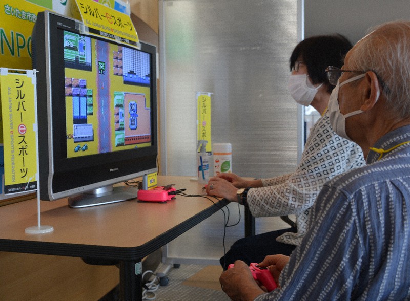 シューティングゲームで対戦するさいたま市民シルバーeスポーツ協会の会員=さいたま市浦和区東高砂町で