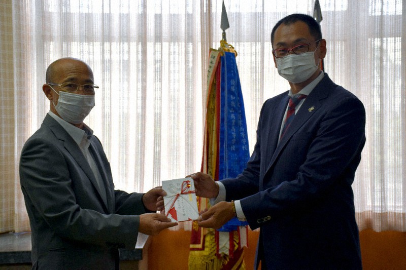 和歌山県高野連の愛須貴志会長(左)に目録を手渡すマスターズ甲子園和歌山支部の井上紘一さん=和歌山市の和歌山商業高で、橋本陵汰撮影