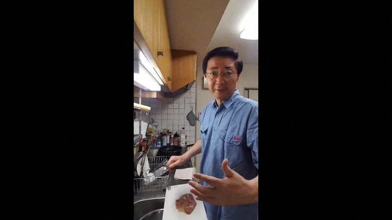 議員宿舎の台所で鶏肉を料理をしながら、小池百合子・東京都知事を批判する山下氏=山下氏のツイッターアカウントから