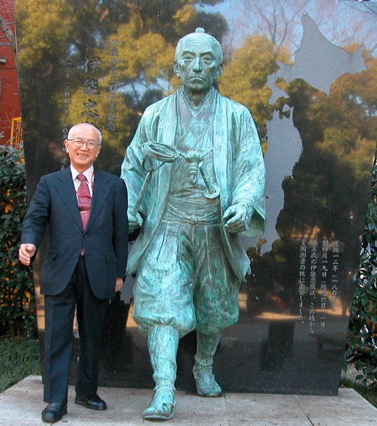 富岡八幡宮にある伊能忠敬像のわきに立つ在りし日の渡辺一郎さん