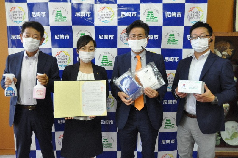 協定締結後、自社で生産する消毒液やマスクを手にする(左から)小島成介・大阪油脂工業社長、稲村和美市長、永田達也・ユニオン工業社長、藤村俊秀・ショウワ社長=兵庫県尼崎市役所で、中村清雅撮影