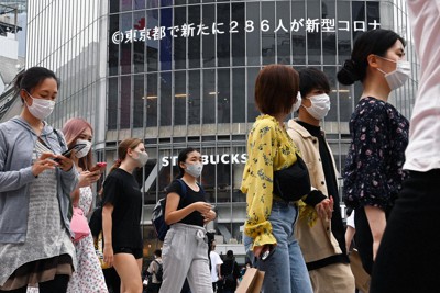 東京都で過去最多の286人が新たに新型コロナウイルスに感染したことを伝えるニュースが流れる中、マスクを着けて渋谷のスクランブル交差点を行き交う大勢の人たち＝東京都渋谷区で2020年7月16日午後5時3分、大西岳彦撮影