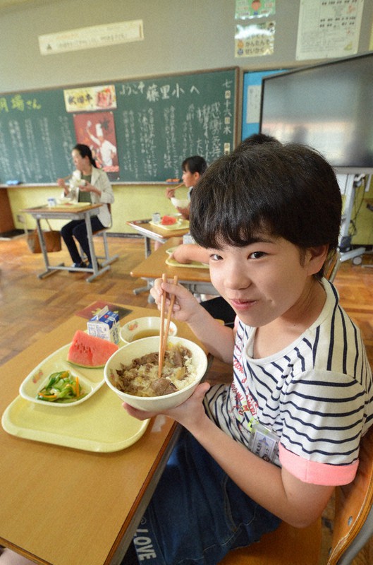 秋田牛の牛丼をうれしそうにほおばる児童たち=秋田県藤里町立藤里小で2020年7月16日、田村彦志撮影