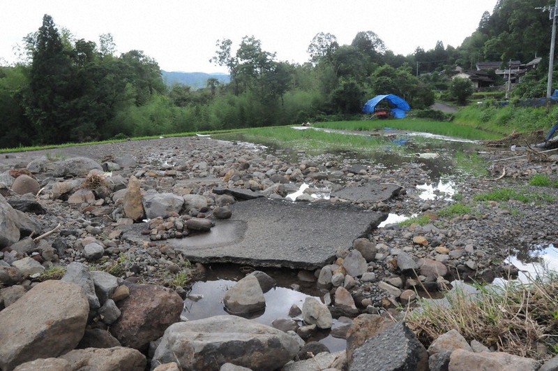 水田に流れ込んだ大量の土砂。近くを通る道路のアスファルトも交ざっている