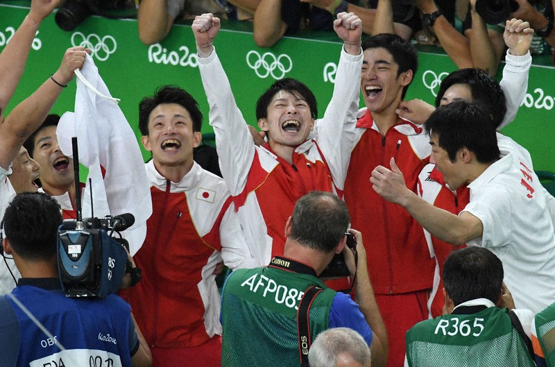 2016年リオ五輪の体操団体総合でメダルが確定し、ガッツポーズで喜ぶ内村航平(中央)、田中佑典(左)ら=三浦博之撮影