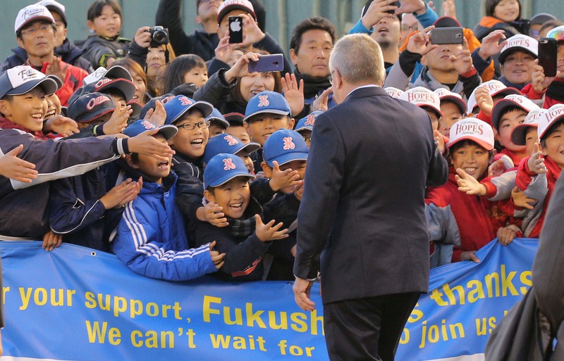 福島県営あづま球場で子供たちの歓迎を受けるIOCのトーマス・バッハ会長(手前)。県民に「復興五輪」への期待感が膨らんだ=福島市で2018年11月24日午後3時55分、宮武祐希撮影