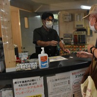 飛沫防止のためビニールシートが設置された「恵びす温泉」の受け付け＝横浜市中区で